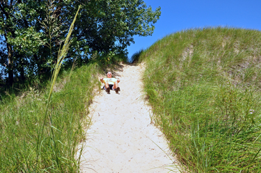 Lee sits down because the dune sand is too hot