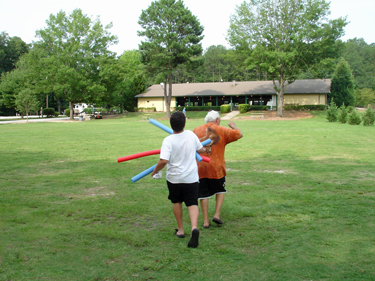 Alex beating Grampy with a noodle on the way to the pool