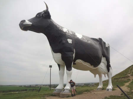 Karen Duquette leans against the World's Largest Holstein cow