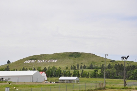 a giant cow on a hill labeled New Salem