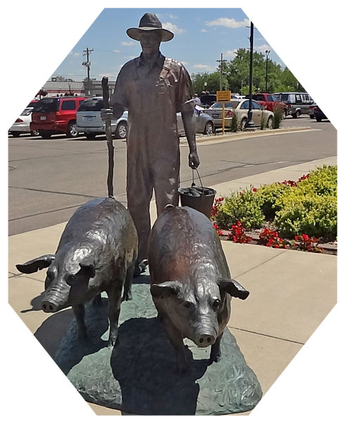 Pig and farmer Statues in the parking lot of the Spam Museum