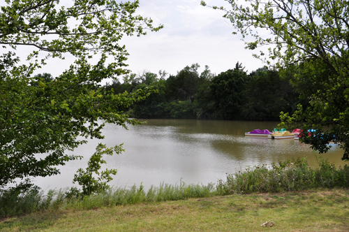 view from the RV is a small lake with paddle boats.