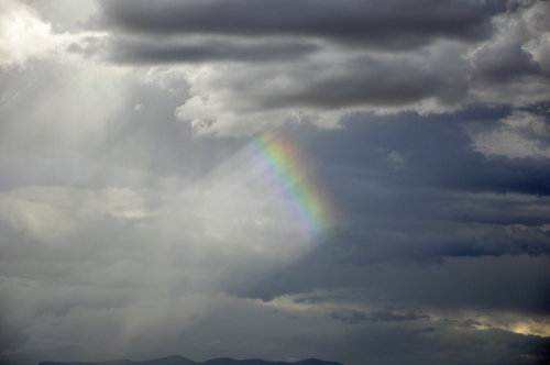 a small piece of a rainbow in the sky.