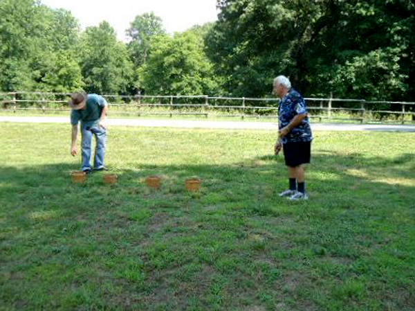 Lee Duquette at Historic Collinsville throwing potatoes into the buckets.