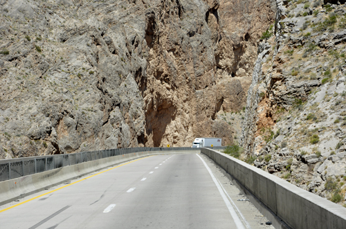 Big mountain cliffs dwarf the RV and semis