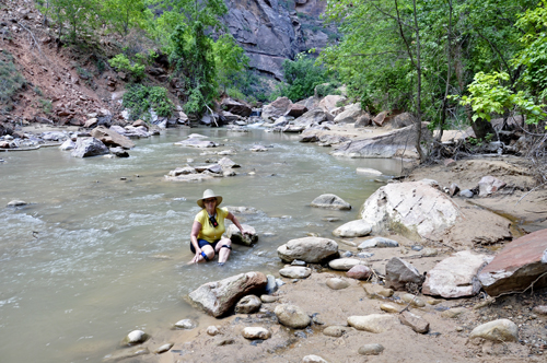 Karen Duquette sitting in the Virgin River at Zion National Park