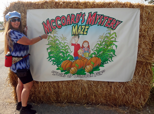 Karen Duquette by the McCoard's Mystery Maze sign