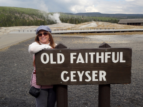 Karen Duquette at the Old Faithful  Geyser sign