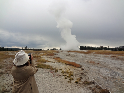 Karen Duquette filming Old Faithful in Yellowstone National Park