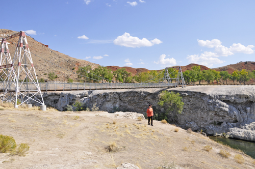 Karen Duquette beside the suspension bridge and Rainbow Terrace