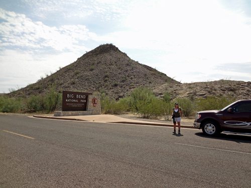 Karen Duquette crossing the street by the Big Bend National Park sign