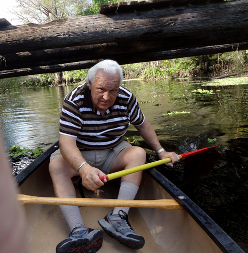 Lee ducks as he paddles under the tree.