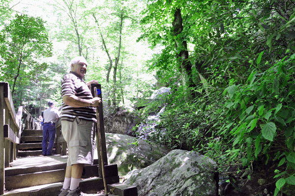 Lee Duquette on a bridge overlook a small cascade of water