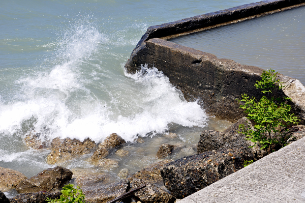 Karen Duquette photographs the waves breaking over the seawall