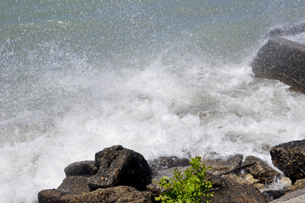 Karen Duquette photographs the waves breaking over the seawall