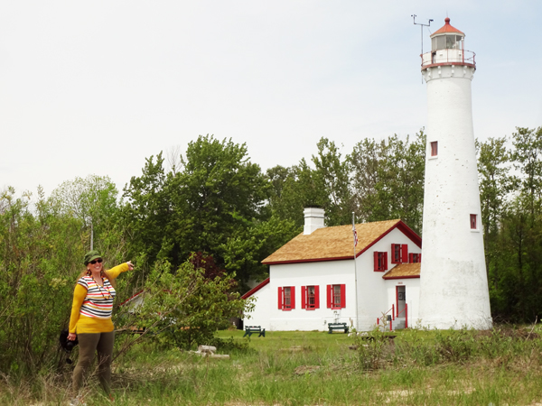 Karen Duquette points to Sturgeon Point Lighthouse 