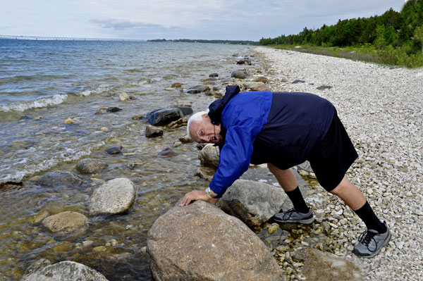 Lee Duquette feels the temperature of the water in Lake Michigan