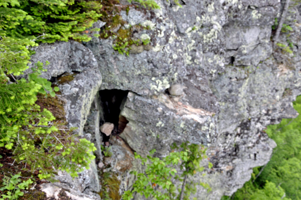 a big hole in the cliff withĀ one lone rock inside the hole