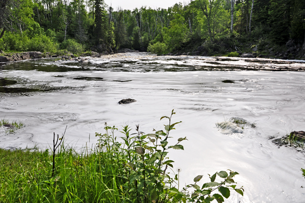 see the foam swirling as the force of the river hits Lake Superior. covered in foam