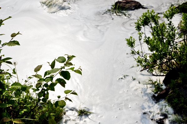 see the foam swirling as the force of the river hits Lake Superior. covered in lots of foam