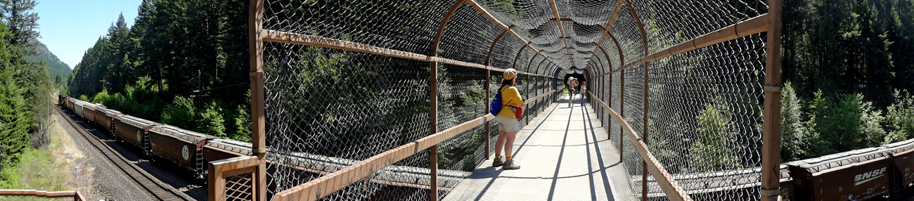 panorama photo of the train going under the bridge, while Karen in on the bridge