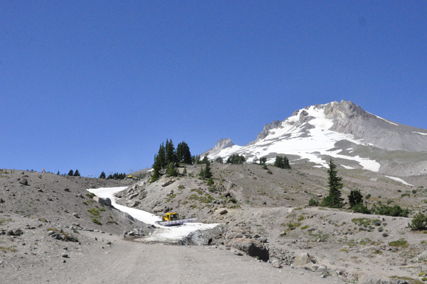 A big machine bringing a snowboard platform down the hill