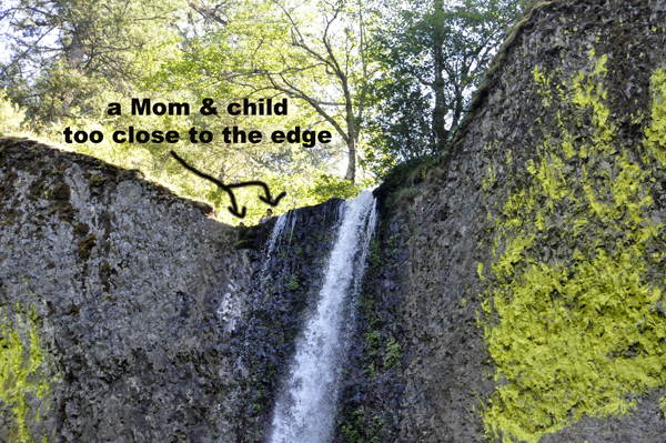 mother and a very small child close to the edge of the falls.