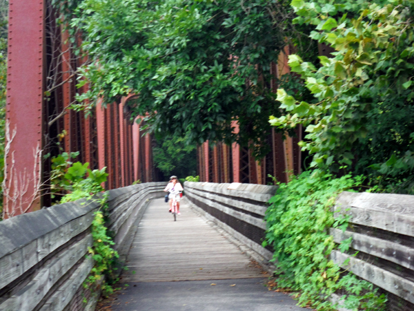 Karen Duquette biking on the bridge