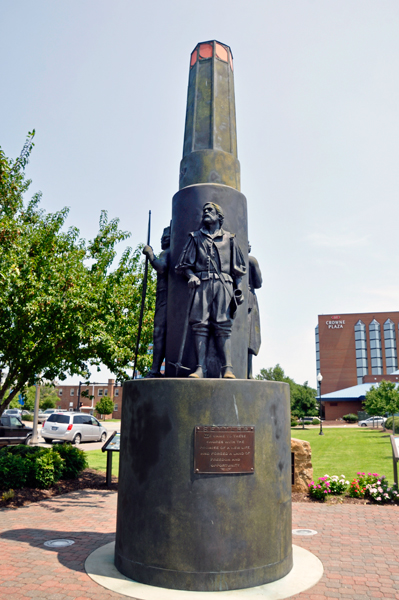 A round monument with three images of leaders