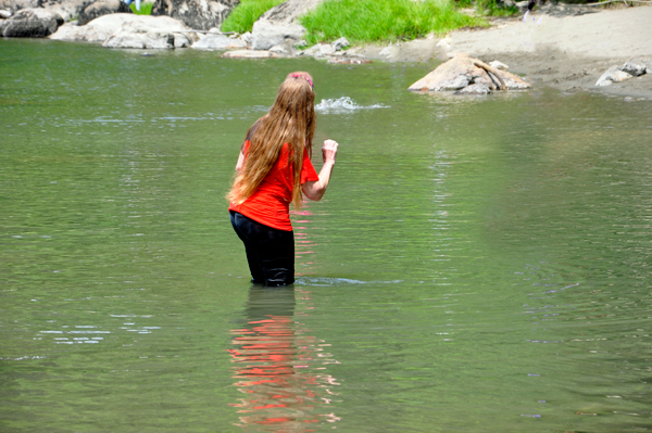 Karen decides to walk a bit in the river.