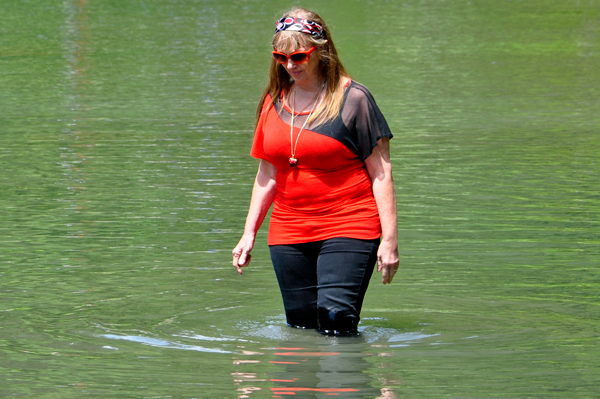 Karen decides to walk a bit in the river.