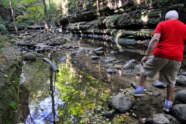 Lee Duquette walking on stones before stepping into the water