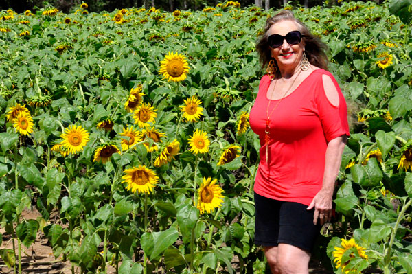 Karen Duquette in a field of sunflowers