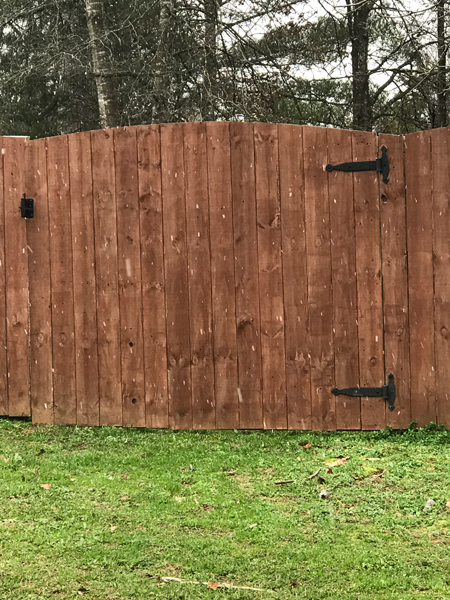 Snow falling near the fence.