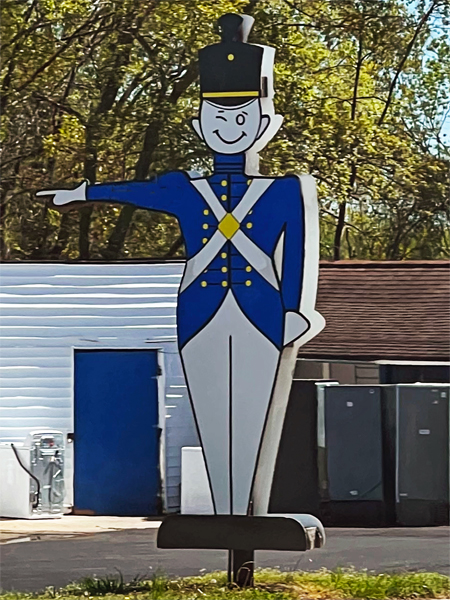 a tall wooden soldier winking