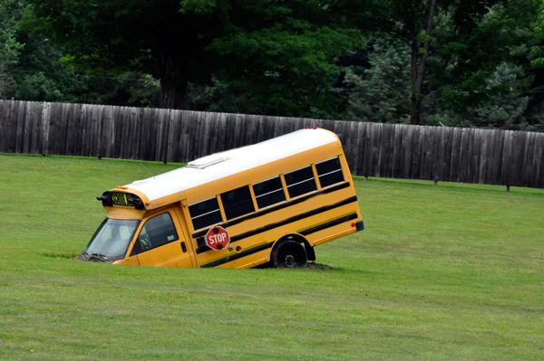 school bus half in the ground