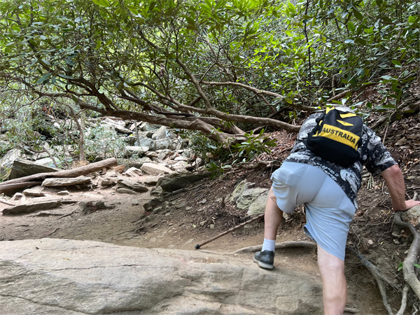 Lee Duquette high stepping up a boulder