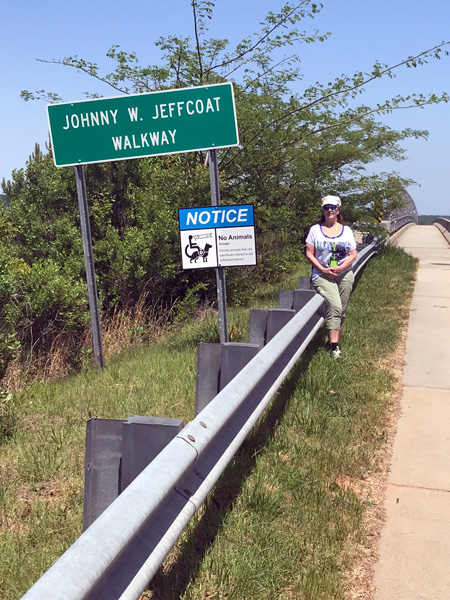 Karen Duquette by the walkway sign