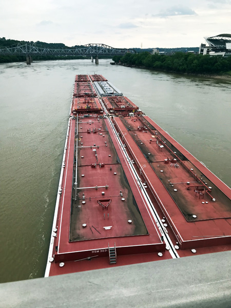 barge emerging out from under the bridge