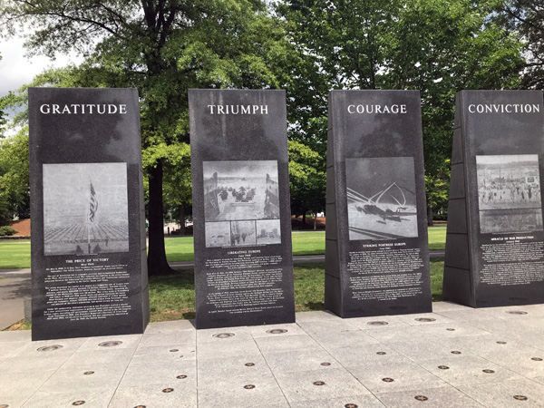 vertical pylons with engraved images from war time