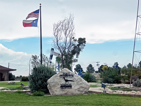 USA flag, the Texas flag, and an oil well at the Visitor Center