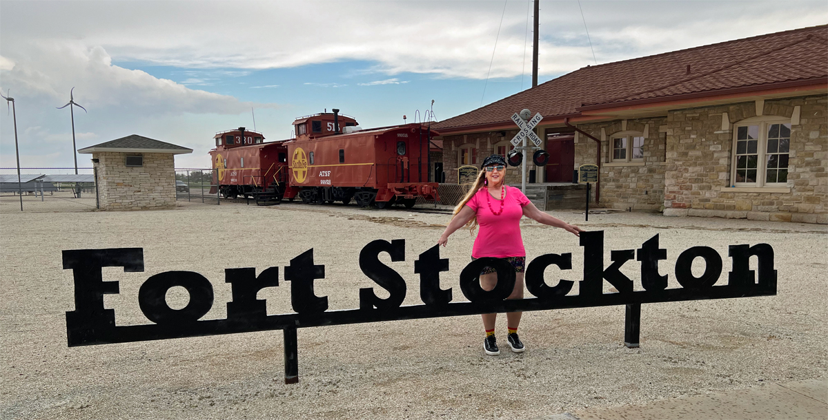 Karen Duquette and the big Fort Stockton sign at the raildroad station