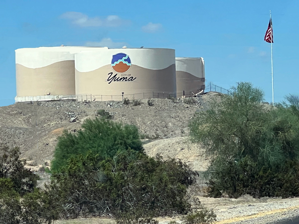 Three City of Yuma water tanks and a USA flag