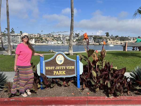 Karen Duquette at the West Jetty View Park sign