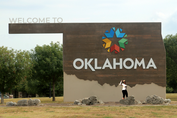 Karen Duquette and a Welcome to Oaklahoma sign