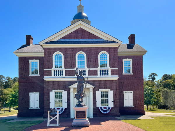 American Village building and statue