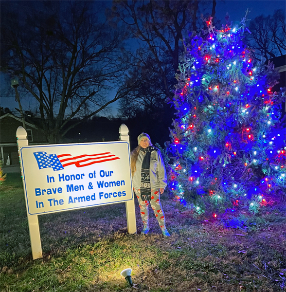 Karen Duquette by an Armed Forces sign