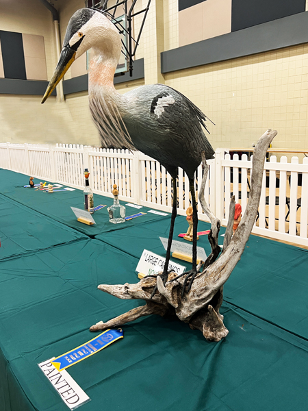 stork woodcarving with a ribbon