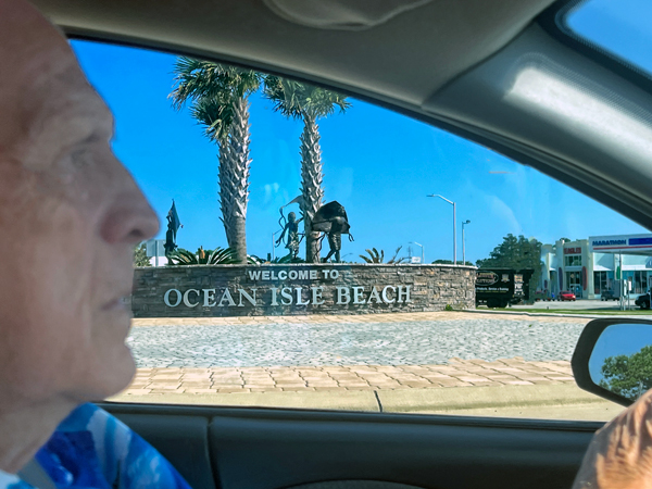 Lee Duquette driving by Ocean Isle Beach sign