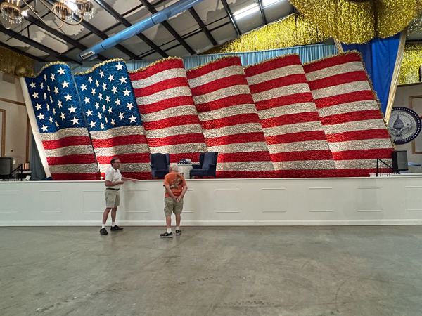 Lee Duquette and the guide by the giant USA flag float